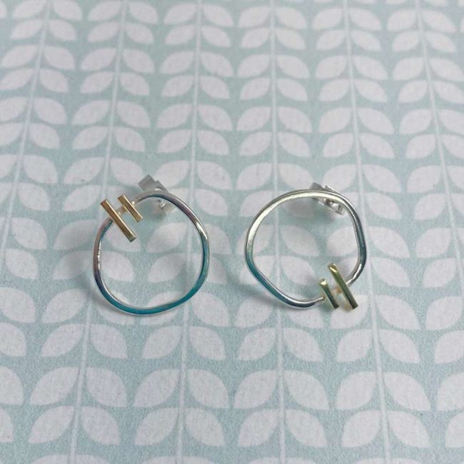 Asymmetric silver and 18ct gold two bar circle studs by Emma Leonard