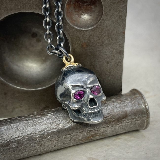 Oxidised silver skull necklace with garnet eyes by Chris Hawkins