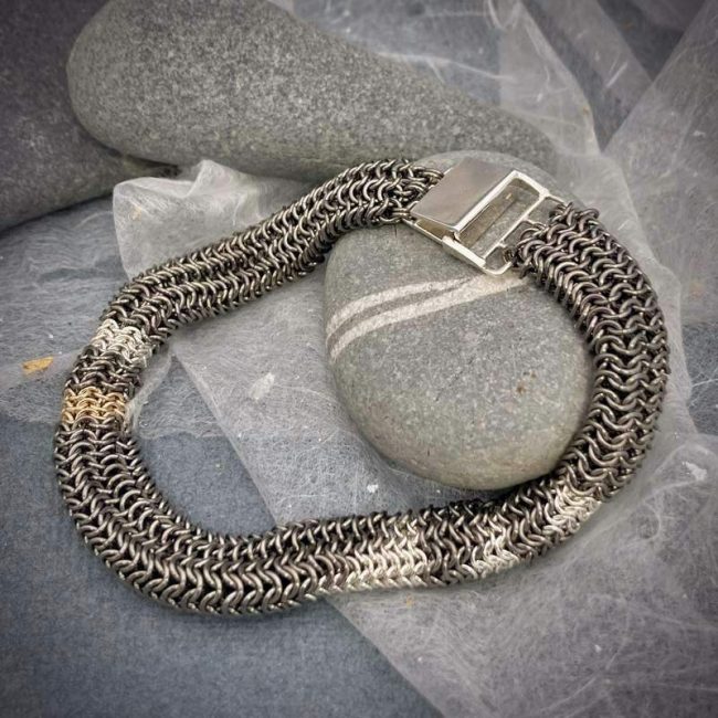 Tube chainmail bracelet in titanium, silver and 9ct gold by Corrinne Eira Evans