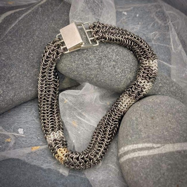 Tube chainmail bracelet in titanium, silver and 9ct gold by Corrinne Eira Evans