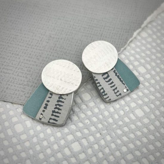 Trax oval studs in silver with white and grey print on turquoise square by Penny Warren
